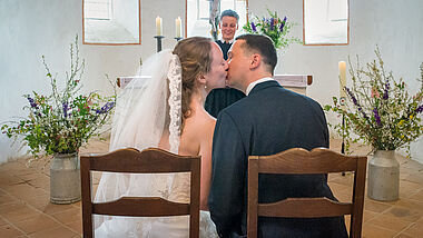 Ein Hochzeitspaar in der Nordkirche gibt sich einen Kuss