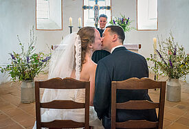 Ein Hochzeitspaar in der Nordkirche gibt sich einen Kuss