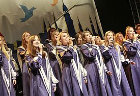 Gospelchor in fliederfarbenen Gewändern, singend