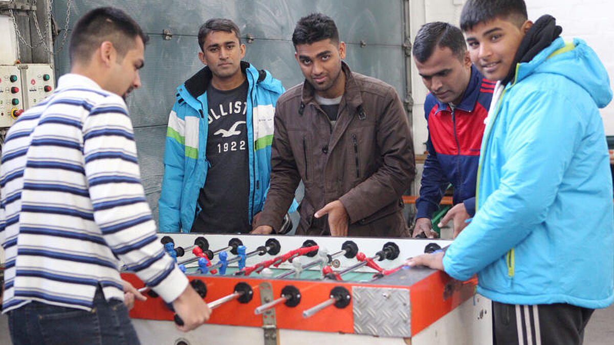 In einer Erstaufnahmeeinrichtung für Flüchtlinge in Berlin (EAE) spielen junge Männer Tischfußball
