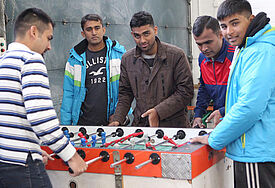 In einer Erstaufnahmeeinrichtung für Flüchtlinge in Augsburg (EAE) spielen junge Männer Tischfußball