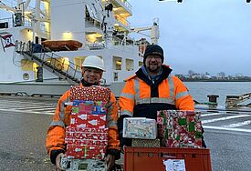 Mitarbeiter der Seemannsmission mit Geschenken 