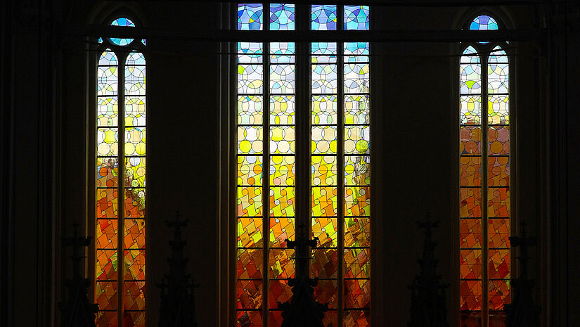 Licht fällt durch bunte GLasfenster in den Greifwalder Dom.