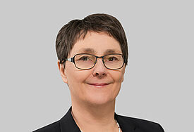 Porträt von Monika Heinold. Die Finanzministerin trägt einen schwarzen Blazer über einem blau-weiß-gestreiften Shirt.