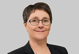 Porträt von Monika Heinold. Die Finanzministerin trägt einen schwarzen Blazer über einem blau-weiß-gestreiften Shirt.