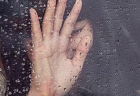 Frau am regennassen Fenster