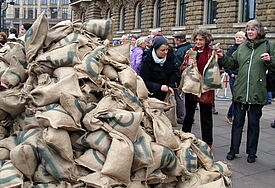 In der Hamburger City wurden symbolisch Geldsäcke von Banken und Versicherungen eingesammelt und auf dem Rathausmarkt verteilt.