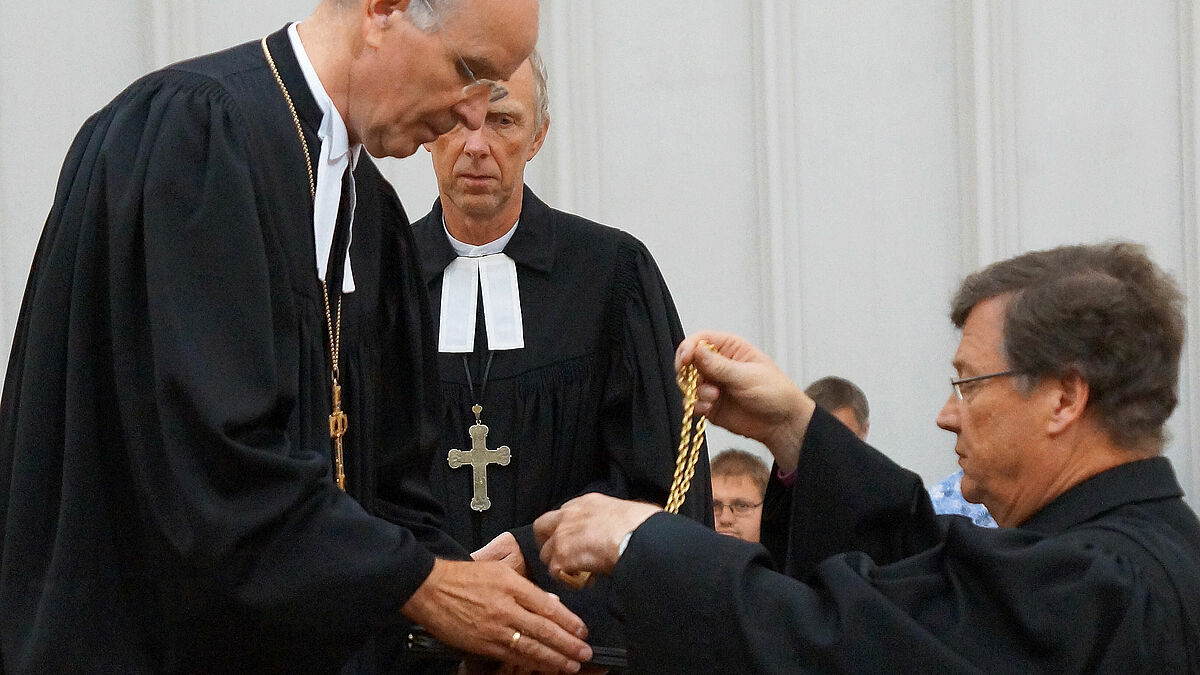 Landesbischof Ralf Meister entpflichtet Bischof Dr. Hans-Jürgen Abromeit und nimmt das Amtskreuz entgegen. Foto: kirche-mv.de/Vogel
