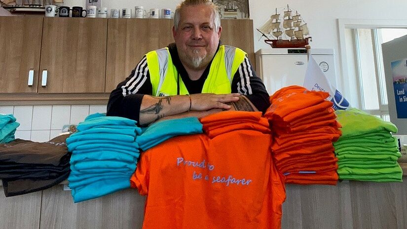 Marco Folchnandt von der Seemannsmission Lübeck mit T-Shirts zum International Seafarers-Day 2025