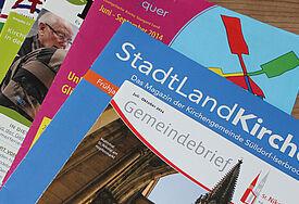 Verschiedene bunte Gemeindebriefe fächerartig übereinander gelegt