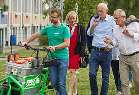 Gemeindepädagoge Robert Stenzel ist mit seinem mobilen Spielzimmer unterwegs. Auf einem Rundgang führt er  Landespastor Paul Philipps (Mitte) und Diakoniepräsident Ulrich Lilie (rechts) durch die Weststadt Parchim. 
