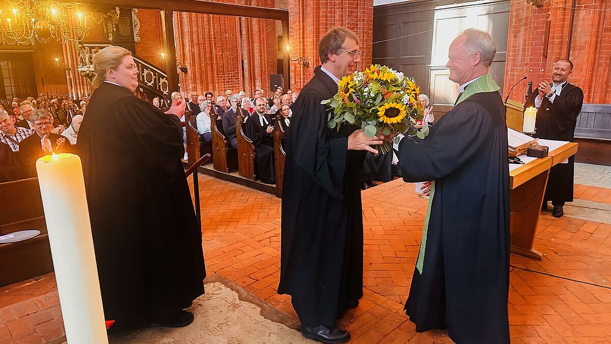 Herzliche Dankesworte und Blumen von Bischof Tilman Jeremias (2.v.r.) an  Pastor Marcus Antonilo, dabei sind Pröpstin Sabine Schümann (l.)sowie Propst Dirk Fey (r. hinten). 