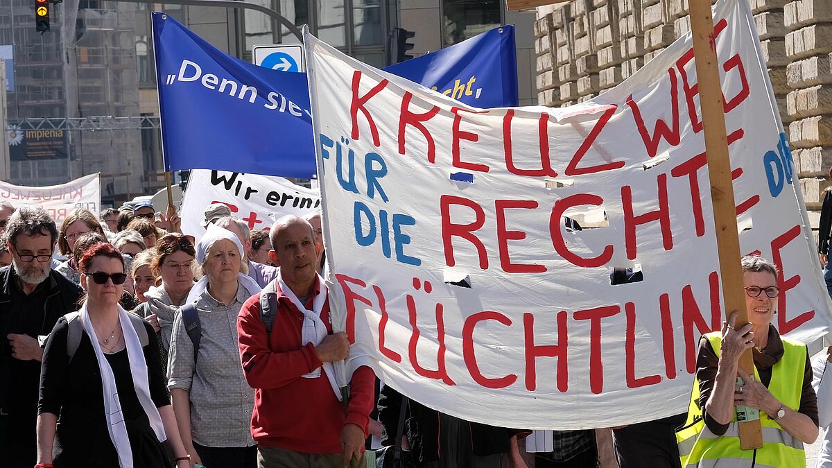 Menschen gehen am Karfreitag einen Kreuzweg in Hamburg