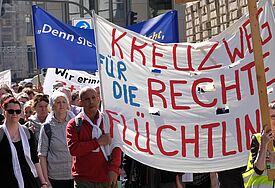 Menschen gehen am Karfreitag einen Kreuzweg in Hamburg