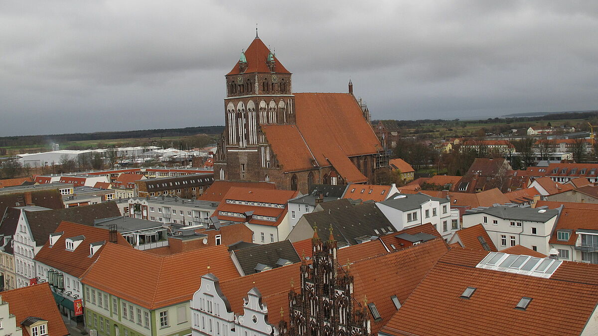 Die Offene Jugendarbeit der drei Evangelischen Altstadtgemeinden in Greifswald unterstützt eine Initiative, die den 8. Mai zum gesetzlichen Feiertag machen möchte. (Foto: Die Altstadt von Greifswald mit Marienkirche)
