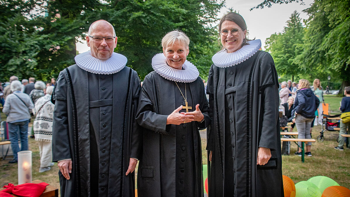 Pastor Martin Klatt, Bischöfin Kirsten Fehrs und Pastorin Margrit Wegner auf der Domwiese in Lübeck