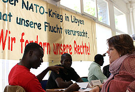 Flüchtlinge aus Libyen, hier im Gespräch mit der Flüchtlingspastorin Fanny Dethloff (rechts) bei einer Pressekonferenz, müssen vorerst weiter auf Hamburgs Straßen leben.