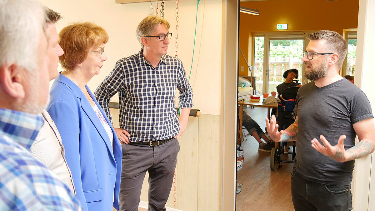 Landesbischöfin Kühnbaum-Schmidt (3.v.r.) im Gespräch mit dem Teamleiter der Tagesförderstätte der Schleswiger Werkstätten Dirk Ehmke (r.) und weiteren Mitarbeitenden 