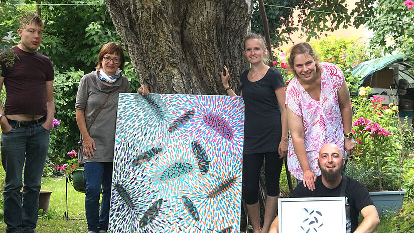 Die Greifswalder Künstlerin Iris Vitzthum (links vom Baum) mit den WG-Bewohnern und Betreuer Niko Voss (rechts unten).
