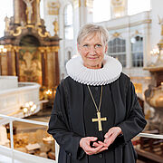 Bischöfin Kirsten Fehrs steht in Ornat und mit Bischofskreuz auf einer Empore der Hamburger Hauptkirche St. Michaelis