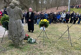 Bischof Jeremias legt an der Gedenkstätte Golm Blumen ab