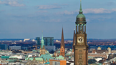 Blick über Hamburgs Innenstadt mit dem Michel (Vordergrund), dem Turm der St. Jacobikirche, der St. Petrikirche und dem Rathaus.