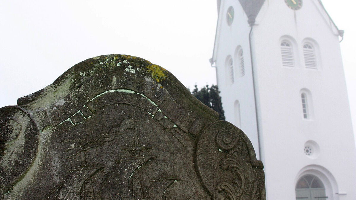 Historischer Grabstein vor der Kirche in Nebel auf Amrum.