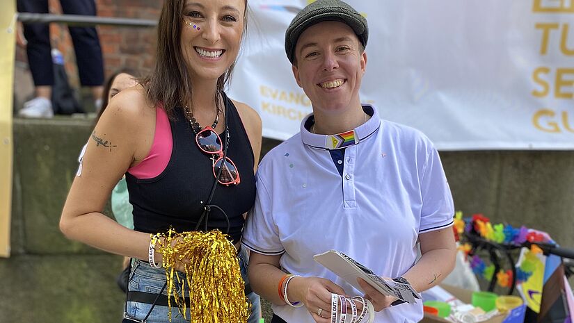 Entertainerin Annie Heger und Pastorin Kathrin Fischer freuen sich über die vielen Teilnehmer:innen und Unterstützer:innen des Hamburger Pride. 