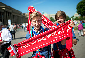 "damit wir klug werden" – diese beiden Helfer zeigen das Motto des Kirchentags