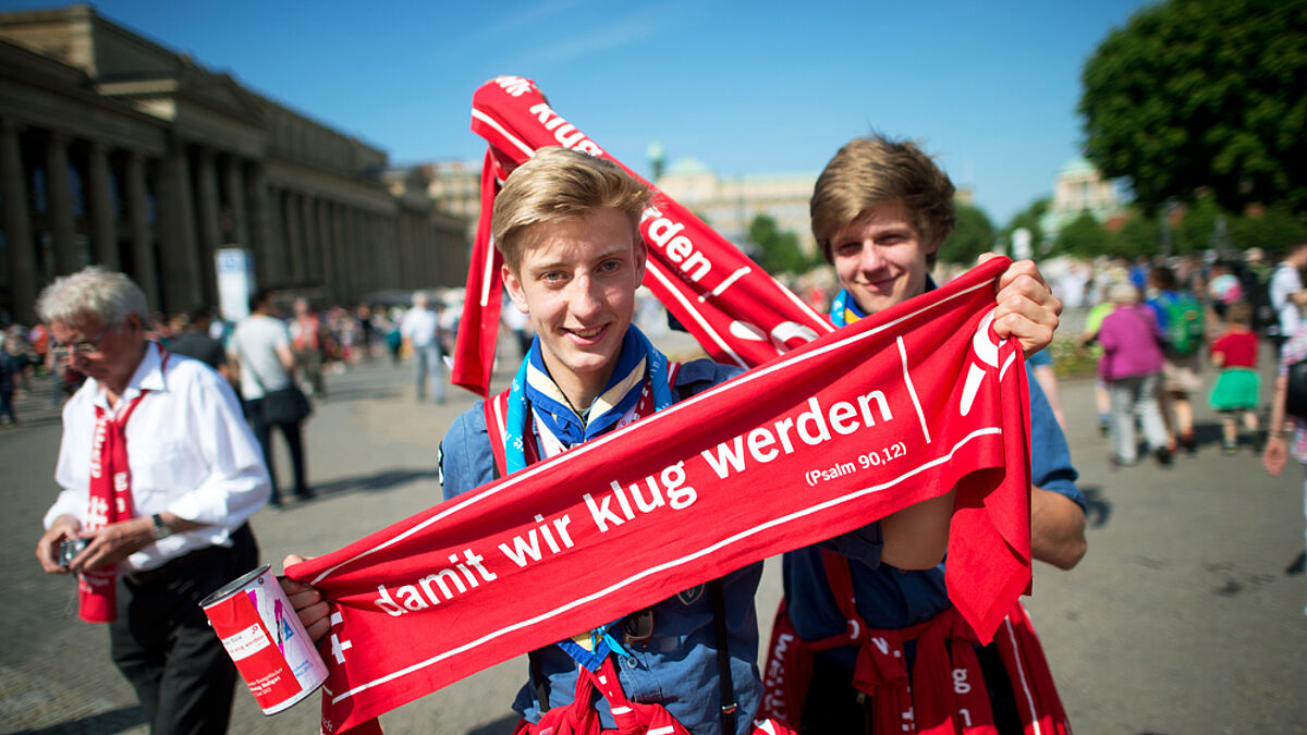 "damit wir klug werden" – diese beiden Helfer zeigen das Motto des Kirchentags