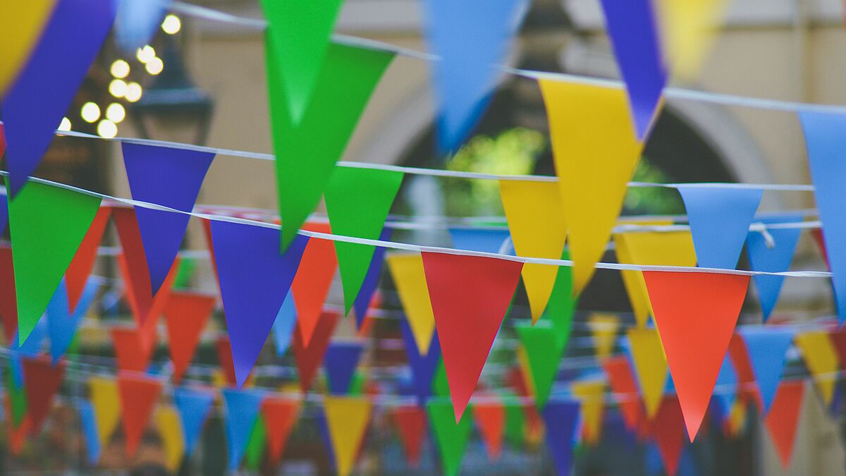 Viele bunte kleine dreieckige Fähnchen in mehreren Reihen