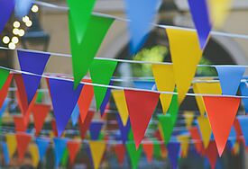 Viele bunte kleine dreieckige Fähnchen in mehreren Reihen