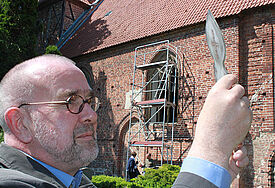 Reinhard Kuhl, Gemeindepastor im vorpommerschen Kartlow, ist auch auch Glasermeister. Hier begutachtet er die Fenster der Pfarrkirche von Neuenkirchen bei Greifswald