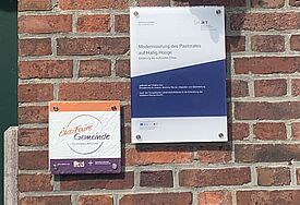 Schild "ÖkoFaire" Gemeinde an einer Kirche auf Hallig Hooge