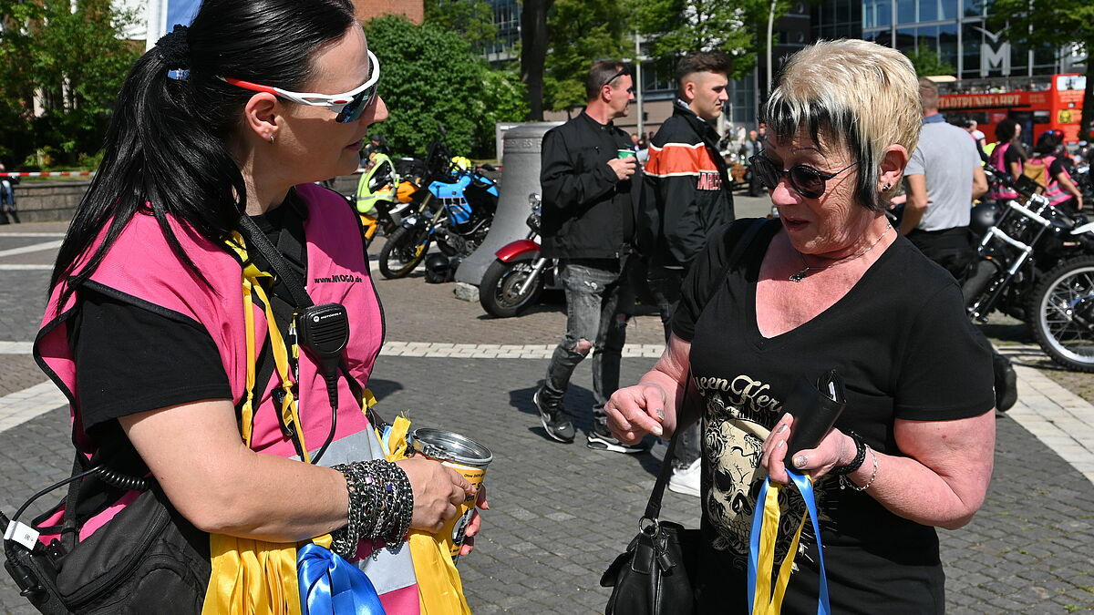 Die Ehrenamtlichen geben Bänder in den Nationalfarben der Ukraine aus – viele Biker möchten ein Zeichen der Solidarität setzen. 