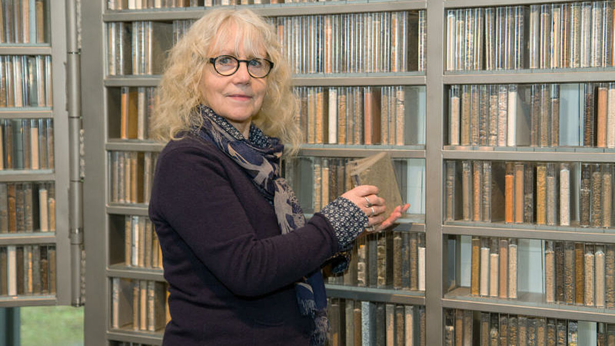 Die Hamburger Kuenstlerin Marianne Greve steht vor dem Altar der evangelischen "Eine-Welt-Kirche" des niedersaechsischen Heidestaedtchens Schneverdingen (Foto vom 26.04.16). Mehr als 5.400 Acryl-Buecher mit Sand, Lehm und Erdkruemeln aus aller Welt bilden den Altar der Kirche. Das Triptychon bietet Platz fuer insgesamt 7.000 gespendete Erdproben aus der ganzen Welt. Die Erde und der Altar sollen ein Symbol fuer die Vielfalt auf unserem Globus darstellen, fuer die Gemeinschaft der Weltbevoelkerung und fuer die Abhaengigkeit vom Boden. Altar und Kirche wurden als Expo-Projekt zur Weltausstellung in Hannover vor 16 Jahren eingeweiht. (Siehe epd-Feature vom 09.05.2016)