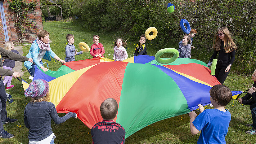 Kinder mit Schwungtuch im Garten von Gode Tied Kinder mit Schwungtuch im Garten von Gode Tied