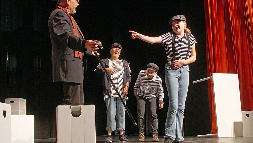 Vier Darsteller stehen auf der Bühne.