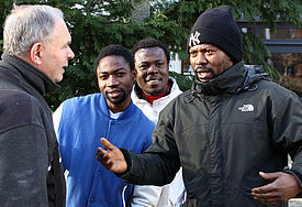 Flüchtlinge aus Afrika: Zakaria Shahadu (2.v.l.), Kwame Damiel (3.v.l.), und Ismail Alhassan mit einem Passanten