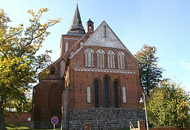 Ansicht suf das Schiff der Kirche, umgeben von Laubbäumen