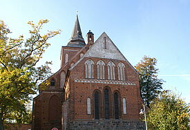 Ansicht suf das Schiff der Kirche, umgeben von Laubbäumen