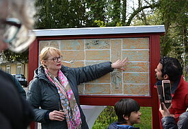 Projektkoordinatorin Susanne Thiesen erklärt die Fliesen, die Lebensgeschichten erzählen.