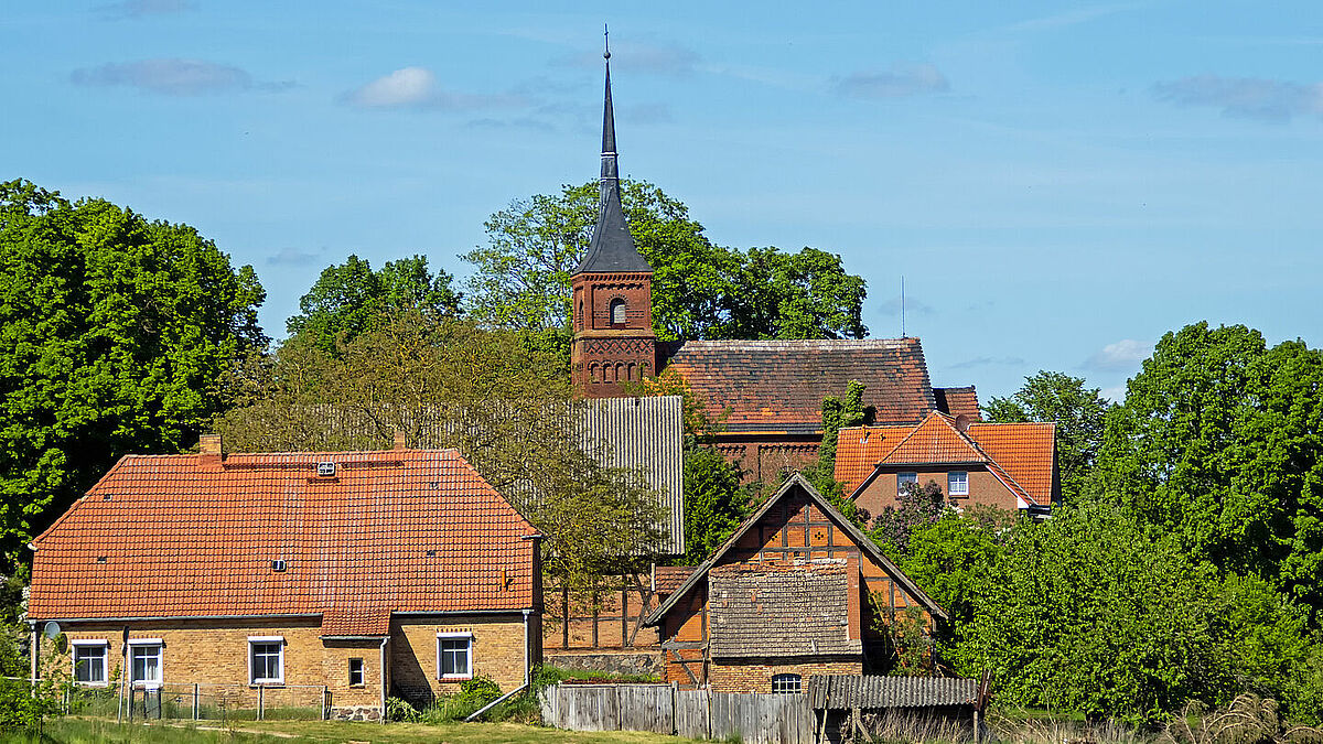 Die Kirche steht gut sichtbar im Mittelpunkt des Dorfes Wustrow am Plätlinsee an der Mecklenburgischen Seenplatte.