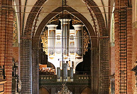 Draufsicht auf eine große prächtige Orgel, umgeben von gotischen Bögen