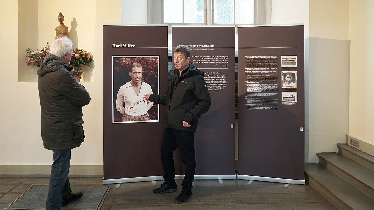Pastor Martin Paulekun zeigt einem Besucher die Ausstellung "FC St. Pauli: Lebenswege 1933-45" in der St. Pauli Kirche.