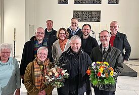 Die Überraschung ist gelungen: Mitten in einer Chorprobe erfuhr Peter Wolff (Mitte) von Pröpstin Petra Kallies, seinen Gemeindepastoren und Kirchengemeinderats- Mitgliedern, dass er zum Kirchenmusikdirektor ernannt wird.