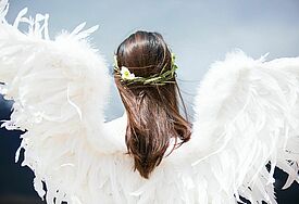 Frau mit Engelsflügeln und Blumenkranz im Haar 