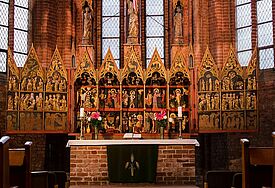 Ansicht des prunkvoll, mit Gold verzierten, aufgeklappten Altars in der Kirche.