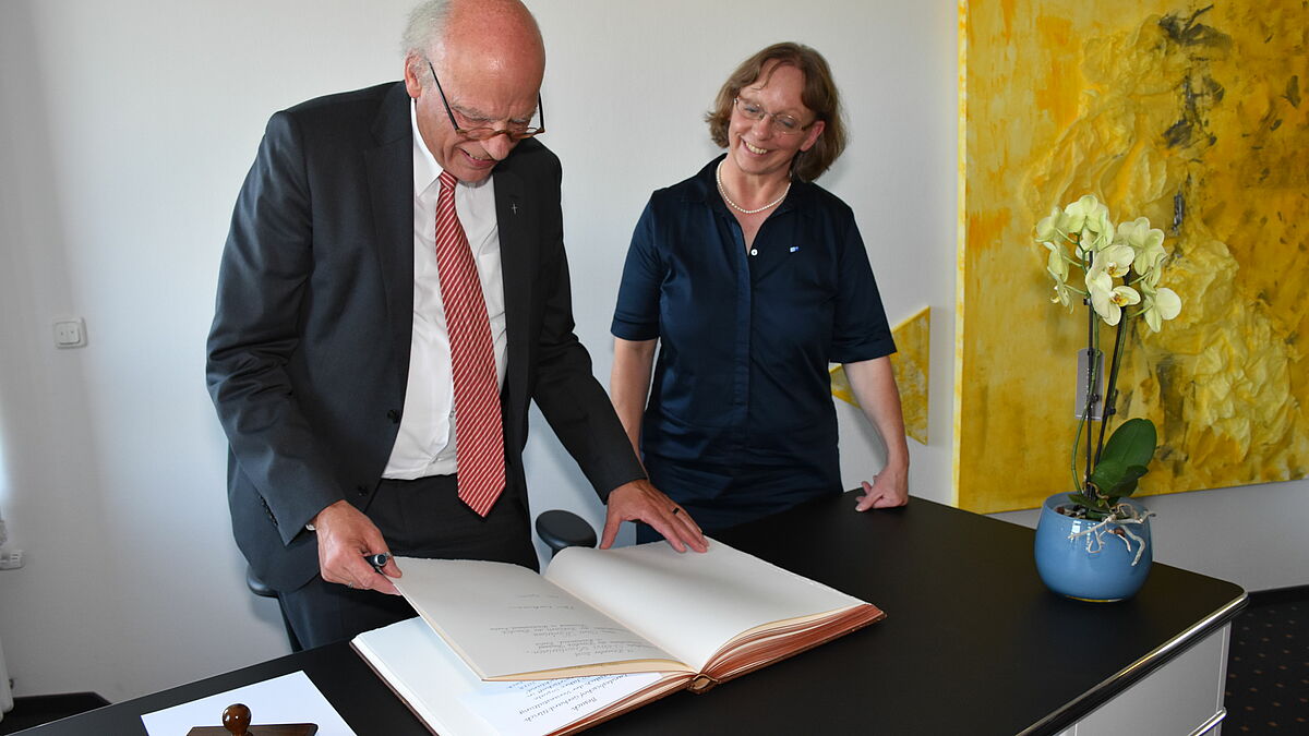 Landesbischof Gerhard Ulrich trägt sich in das Goldene Buch der Industrie- und Handelskammer (IHK) in Lübeck ein.