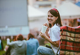 Frau im Open-Air-Kino mit Getränk